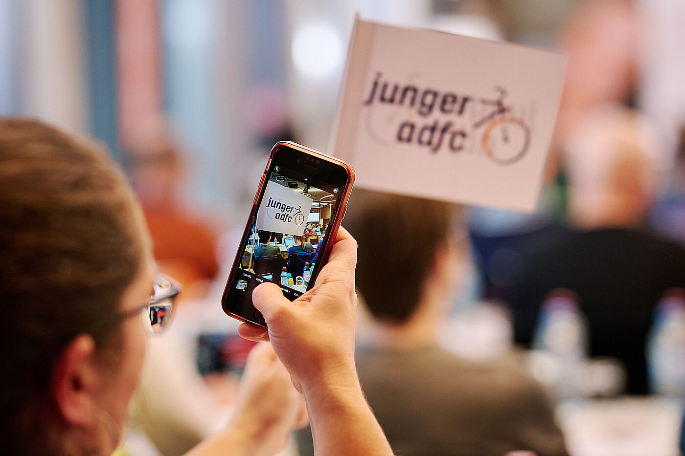 Person macht Foto mit dem Smartphone von der Veranstaltung